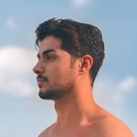 Profile of a contemplative young man against a tranquil blue sky in Baghdad, Iraq.